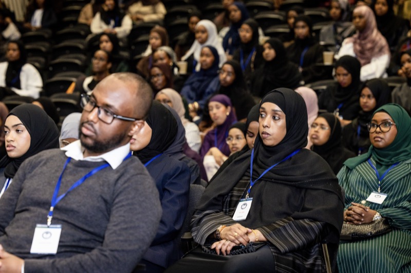 Members in the audience, wearing conference lanyards