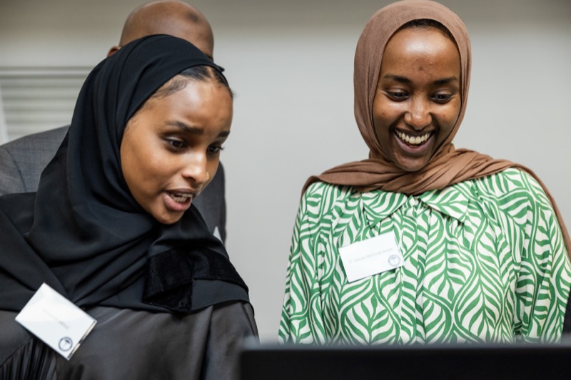 Two BSMA members laughing as they read a laptop screen together